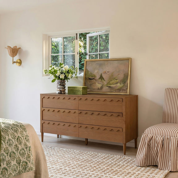 Light brown 6-drawer dresser with wavy fronts, shown in a bedroom setting