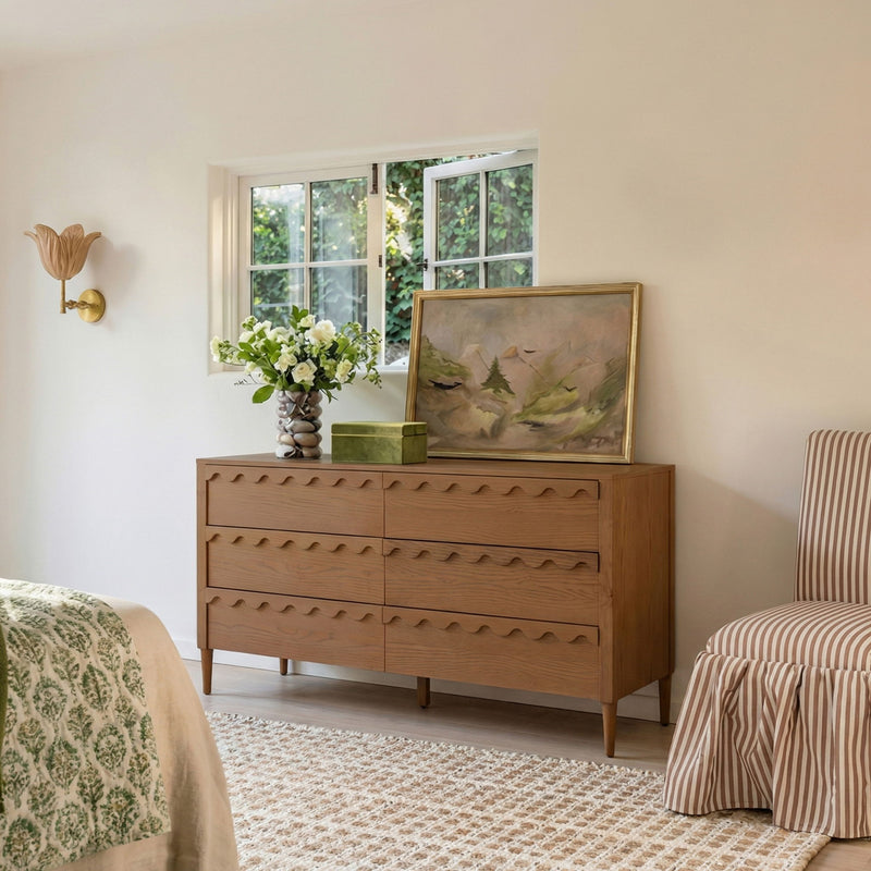 Light brown 6-drawer dresser with wavy fronts, shown in a bedroom setting