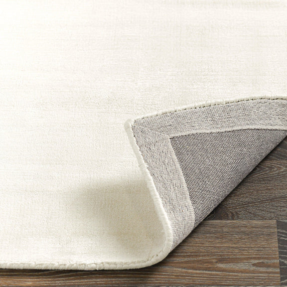 Ivory flatweave area rug with visible stitched border edge