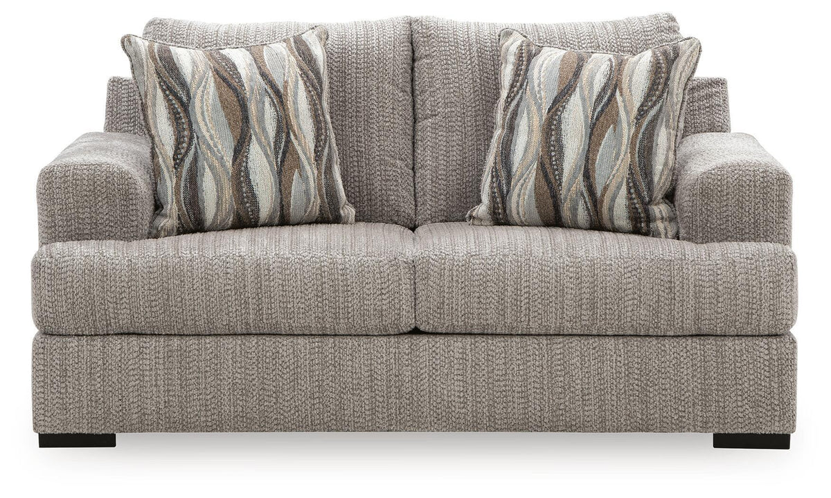 Gray textured loveseat with armrests, two seat cushions, and striped wave throw pillows
