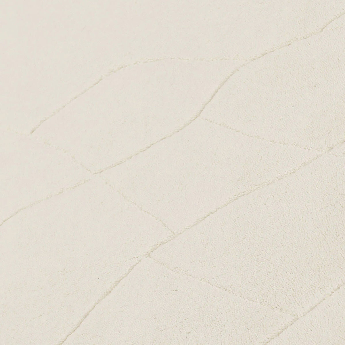 Ivory wool rug close-up with fine raised line pattern on the surface