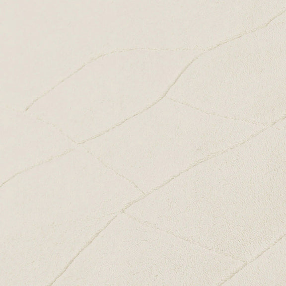 Ivory wool rug close-up with fine raised line pattern on the surface