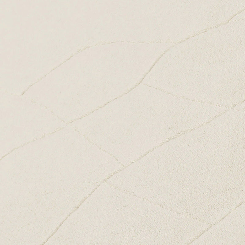 Ivory wool rug close-up with fine raised line pattern on the surface