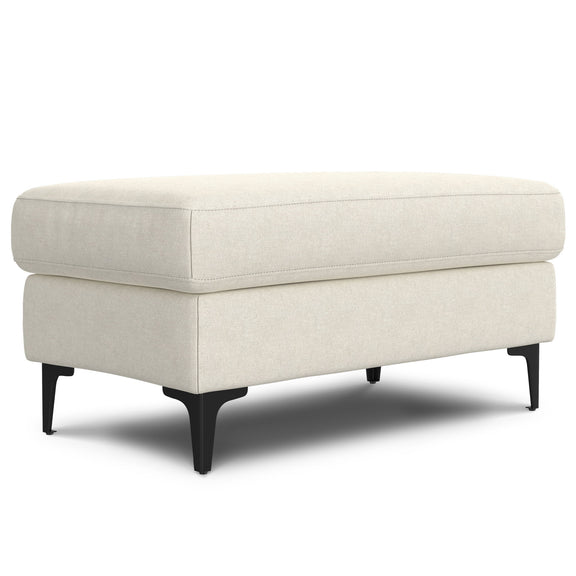 Cream upholstered ottoman with a cushioned top and black tapered legs, shown at an angle.