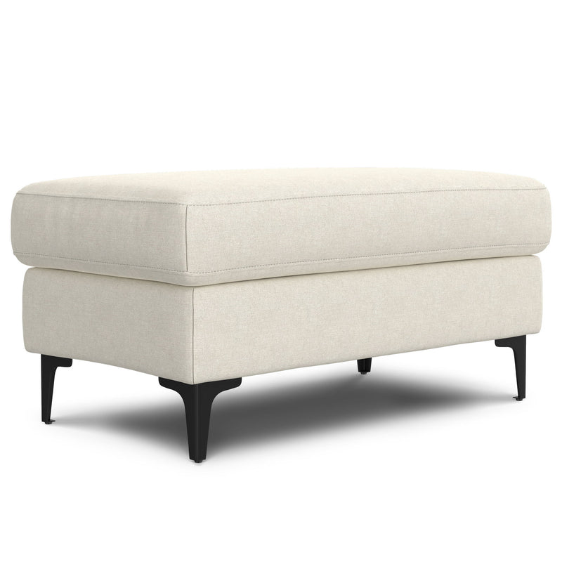 Cream upholstered ottoman with a cushioned top and black tapered legs, shown at an angle.