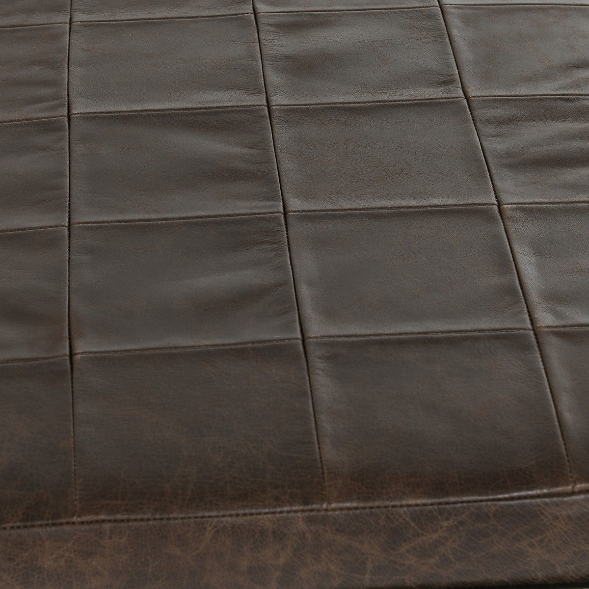 Close-up of dark leather bench seat with square stitched design