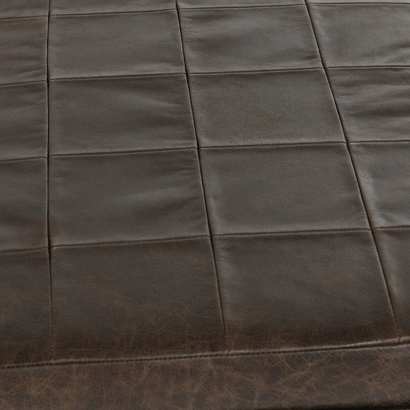 Close-up of dark leather bench seat with square stitched design