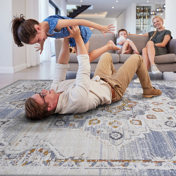 Medallion area rug in beige and blue with distressed pattern, rectangular on floor.