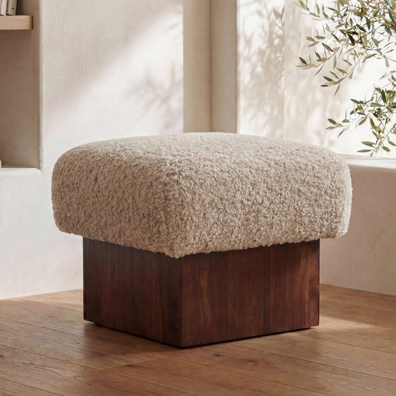 Round-top cream faux shearling ottoman with dark brown wood base