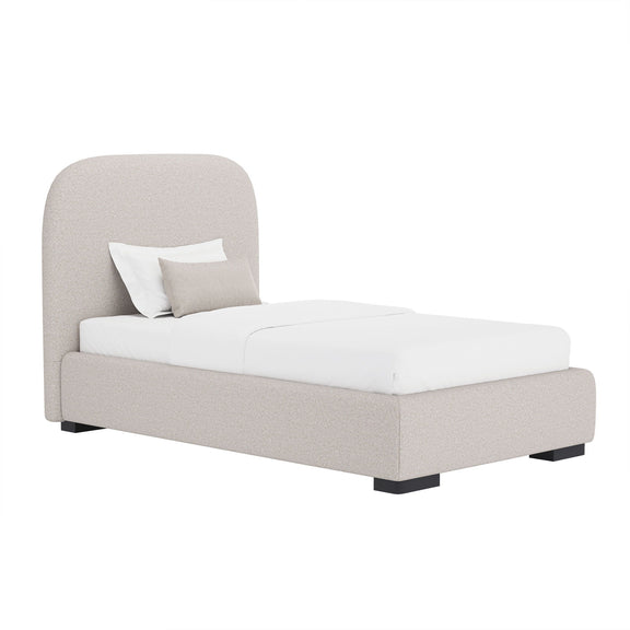 Beige upholstered bed with rounded headboard and low footboard, with white bedding