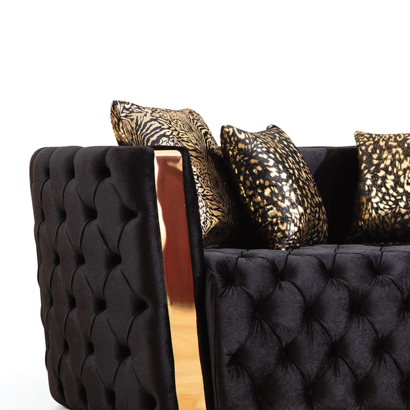 Close-up of sofa's button-tufted arm, gold-finish accent, and patterned cushions