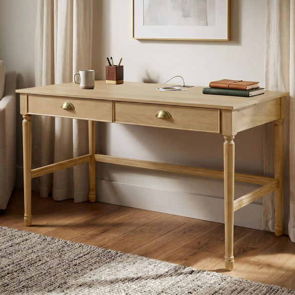 Light brown writing desk with two drawers, brass-tone pulls, and lower shelf