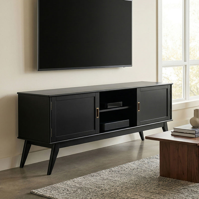 Mid-century low TV media stand in black wood with two doors and open center shelf.