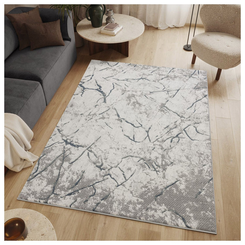 Gray geometric area rug with abstract veined pattern in a living room setting