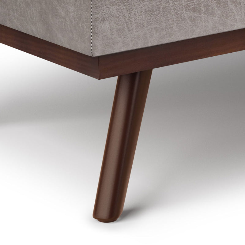 Brown faux leather storage ottoman with mid-century angled legs