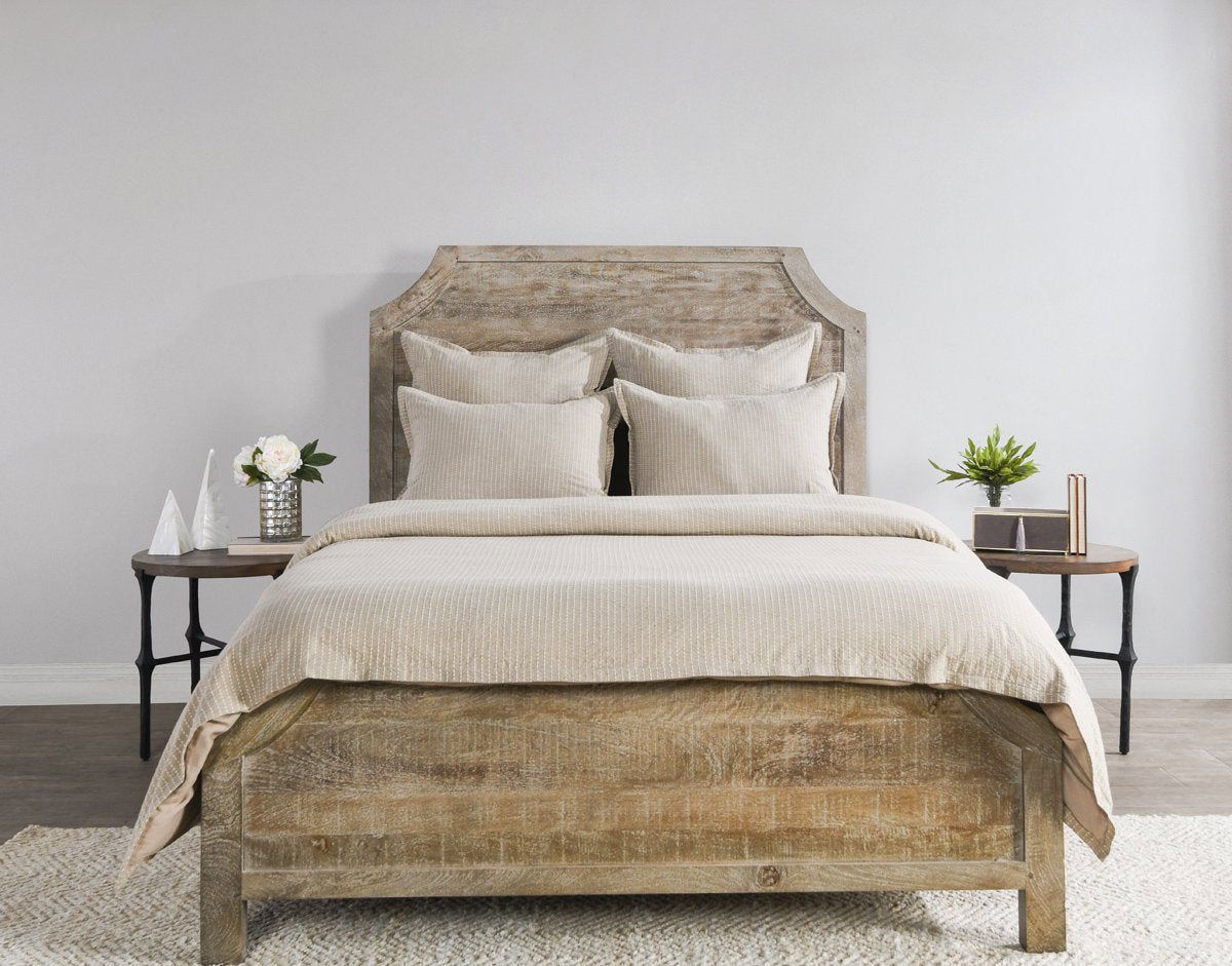 Beige textured duvet with two decorative pillows on bed