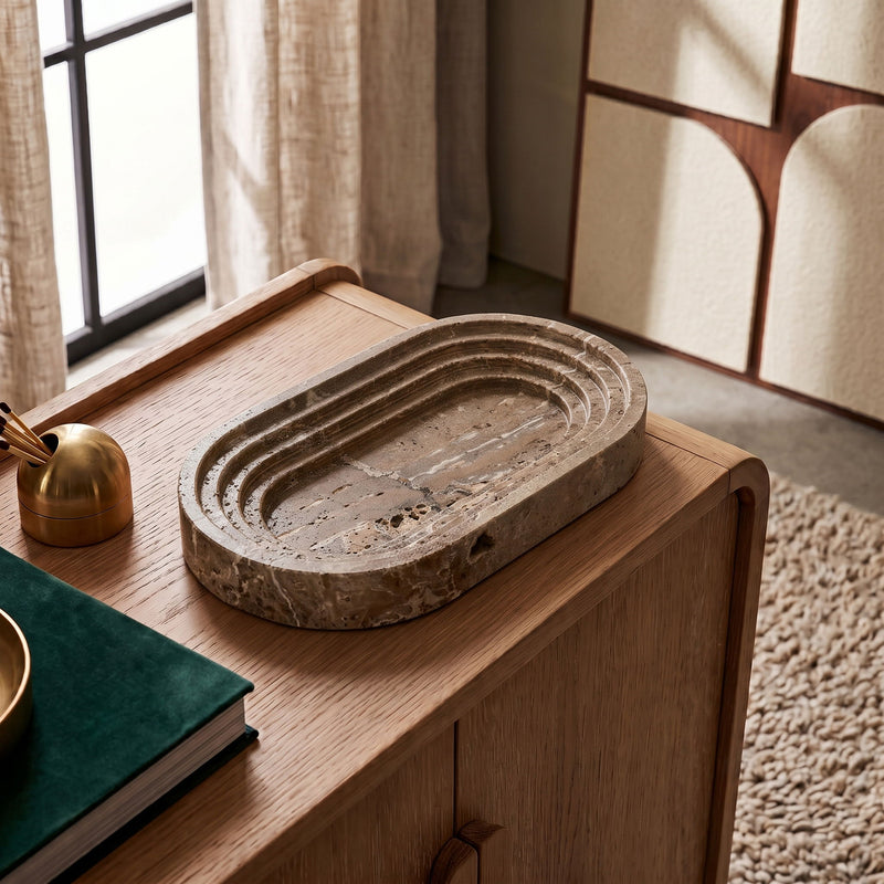 Marble oval tray on a wooden tabletop, shown from a front-left angle