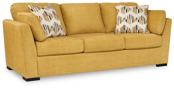 Keerwick sunflower upholstered sofa with two patterned accent pillows and dark feet