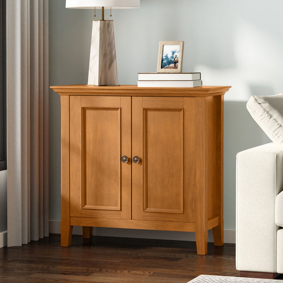 Light brown two-door storage cabinet with paneled doors and round metal knob pulls
