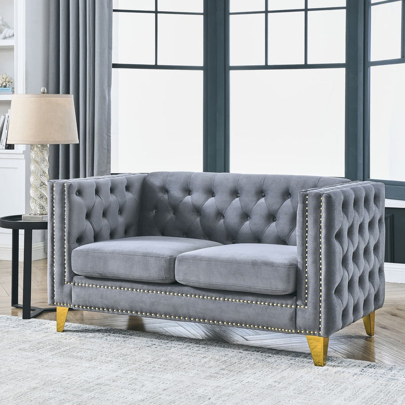Dark gray button-tufted sofa with nailhead trim, two cushioned seats, and gold legs