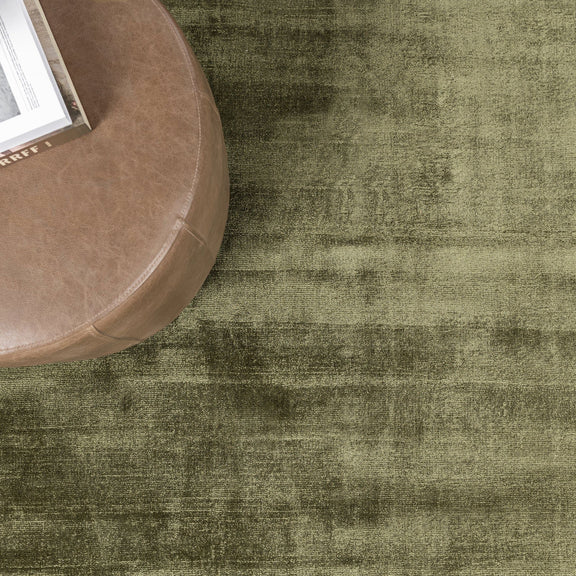 Olive green distressed area rug with mottled, vintage-look finish