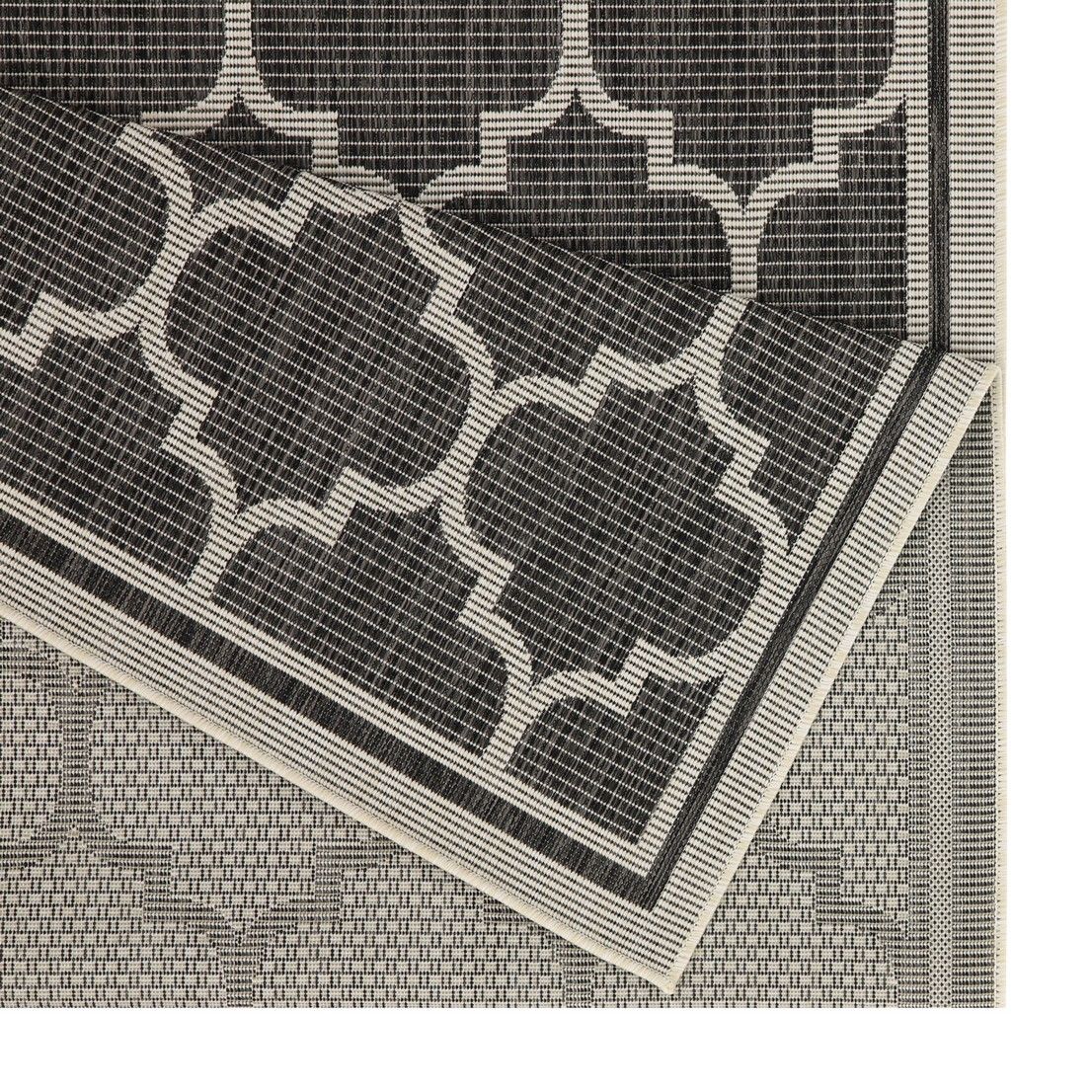 Polypropylene area rug close-up of dark gray quatrefoil pattern and border trim