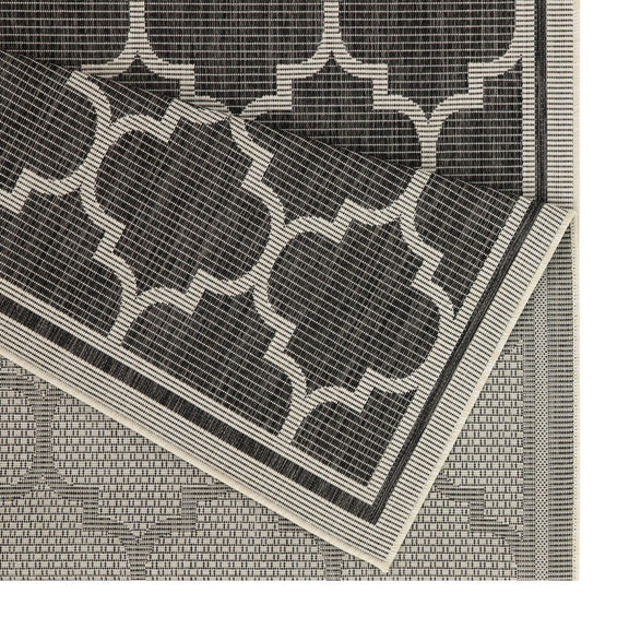 Polypropylene area rug close-up of dark gray quatrefoil pattern and border trim