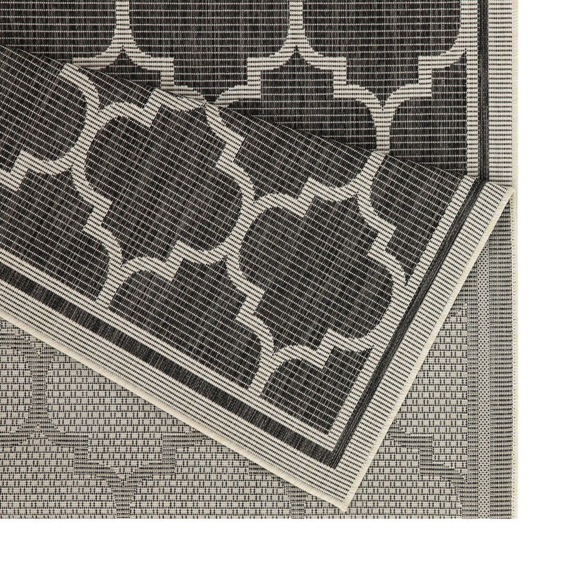 Charcoal polypropylene area rug close-up showing quatrefoil pattern and border
