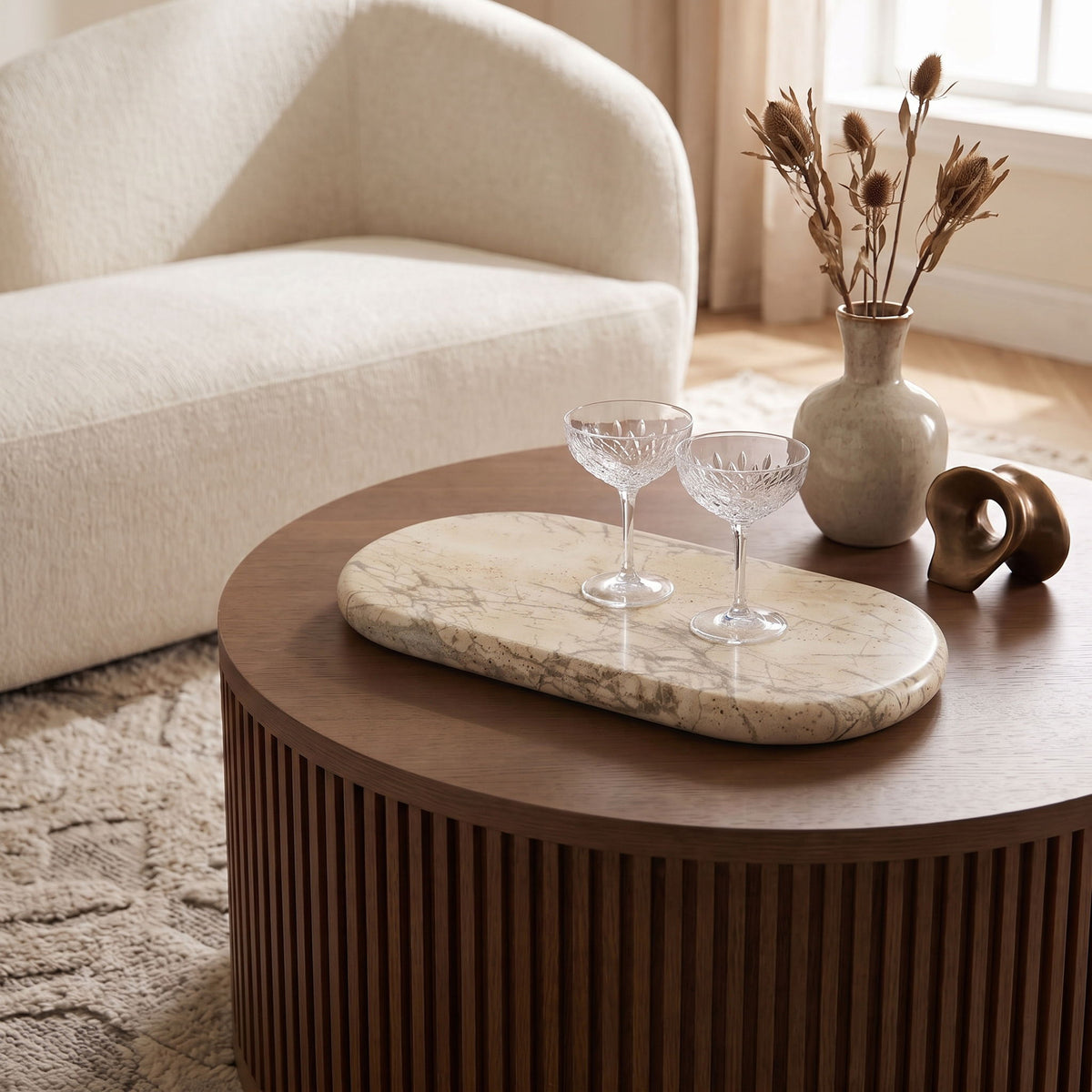 Beige travertine oval serving tray with veined surface on tabletop