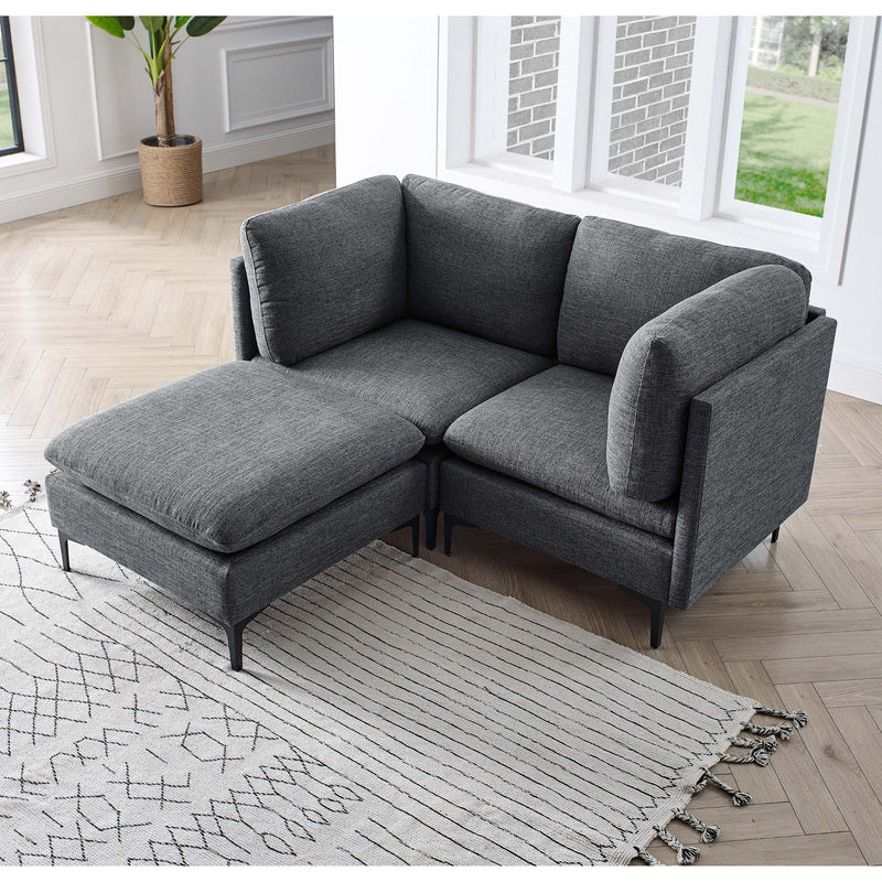 Dark gray modular sectional sofa with tall legs and chaise ottoman, fabric upholstery