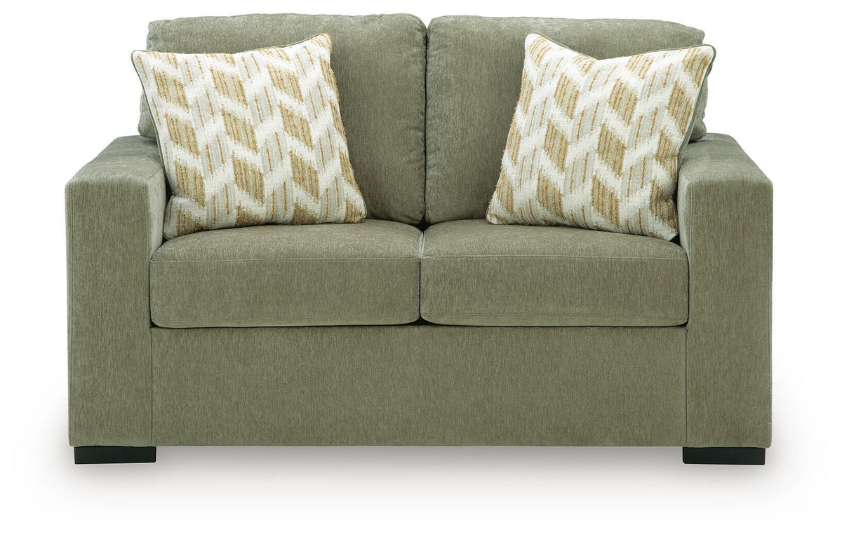 Green fabric loveseat with two geometric throw pillows and squared arms
