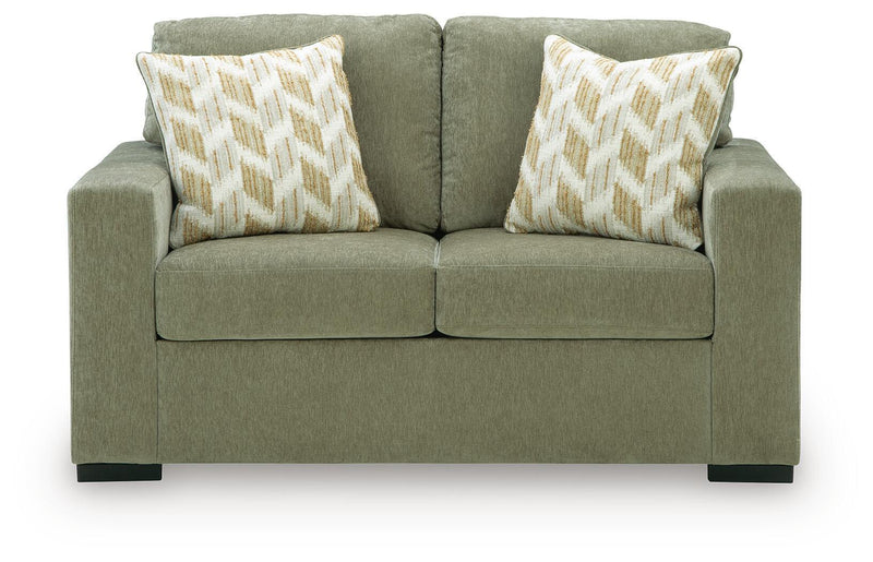 Green fabric loveseat with two geometric throw pillows and squared arms