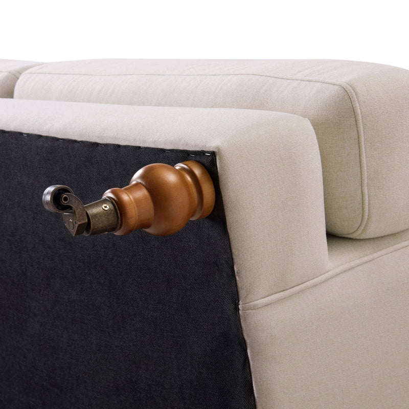 Beige sofa corner with dark fabric panel and bronze knob detail on the side.