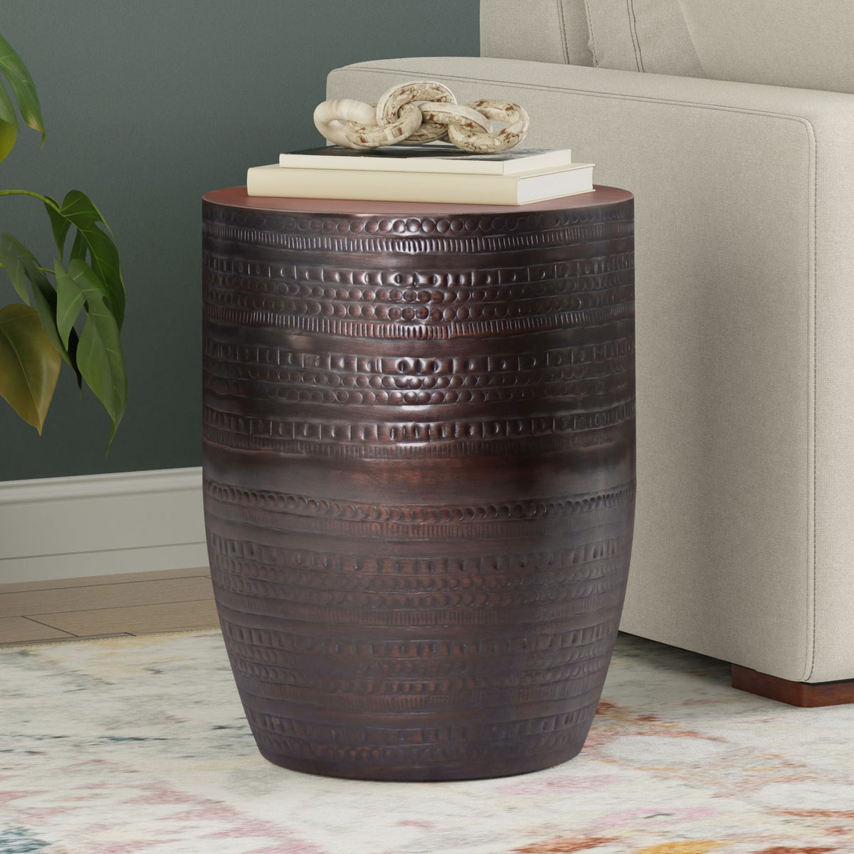 Dark brown metal drum accent table with embossed horizontal bands and round top