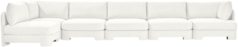 White armless sectional sofa with rounded chaise corner and back pillows