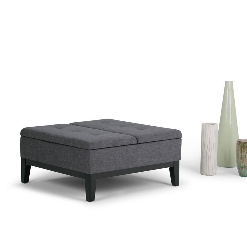 Dark gray fabric storage ottoman with tufted top and tapered dark wooden legs
