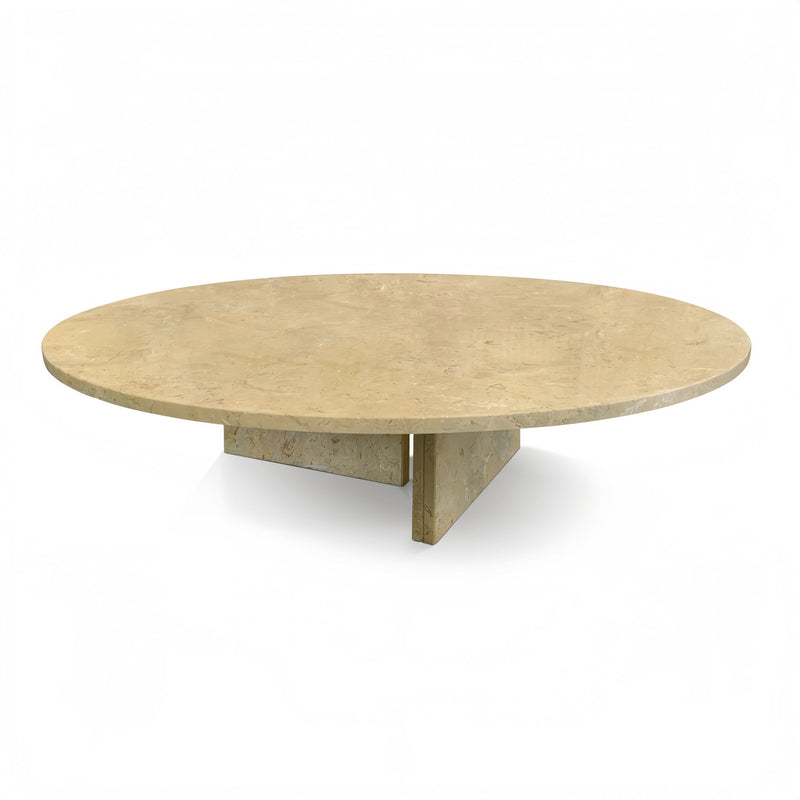 Round beige stone coffee table with distinctive veining and tripod-like angular legs.