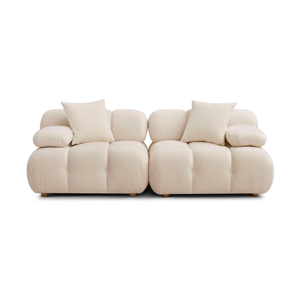 Modular loveseat sofa in cream upholstery with rounded arms and tufted seat sections
