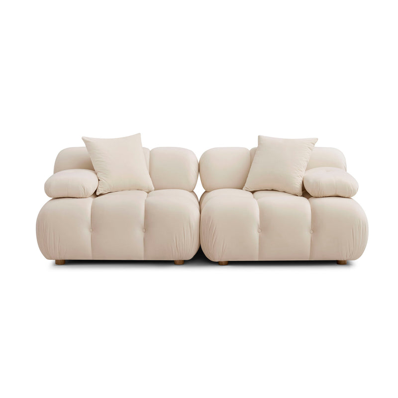 Modular loveseat sofa in cream upholstery with rounded arms and tufted seat sections