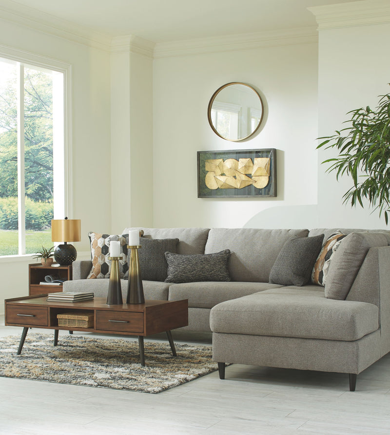 Gray sectional sofa with chaise and square arms, styled with decorative pillows.