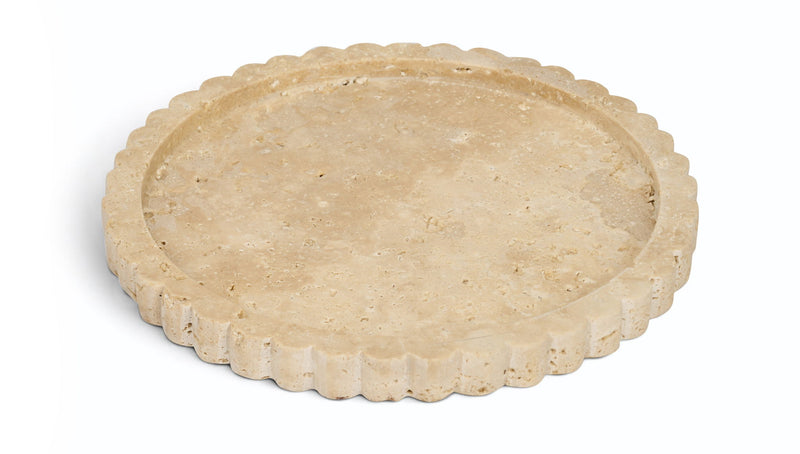 Beige travertine tray with scalloped rim, round shallow surface.