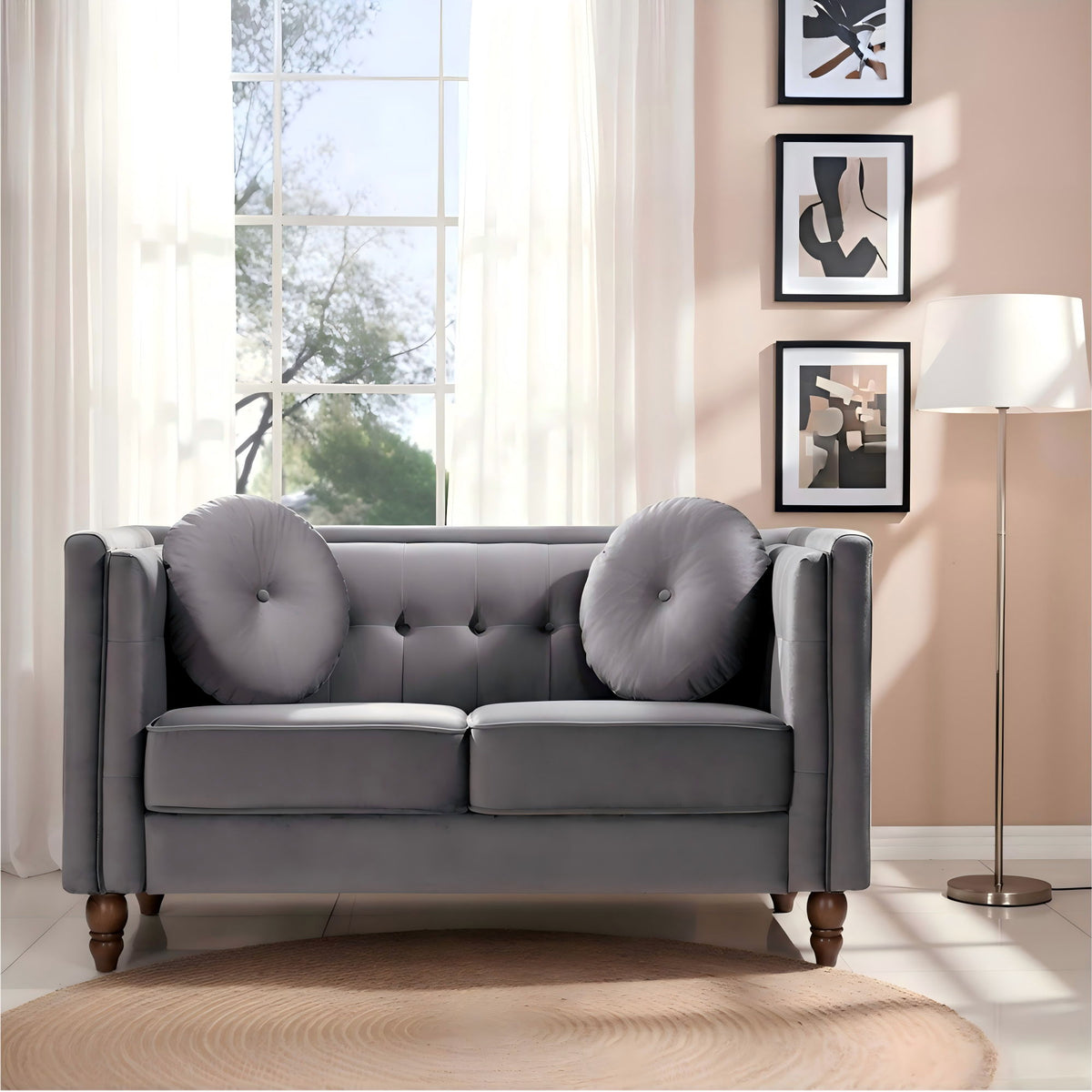 Tufted 2-seater loveseat in dark gray, with round arm cushions and button-tufted back.