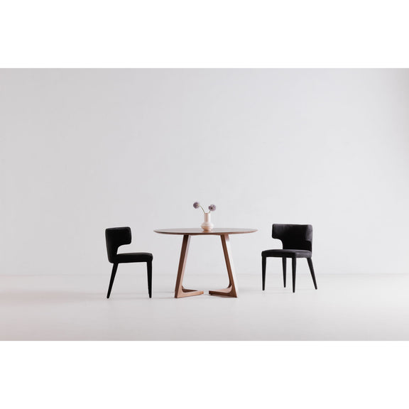 Round walnut dining table with angular leg frame, set with two chairs