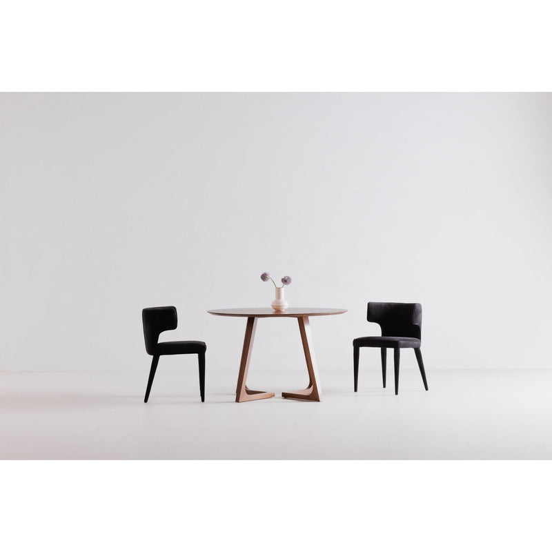 Round walnut dining table with angular leg frame, set with two chairs