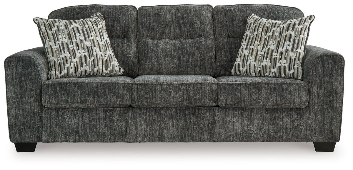 Gunmetal sofa with two patterned accent pillows and tufted armrests