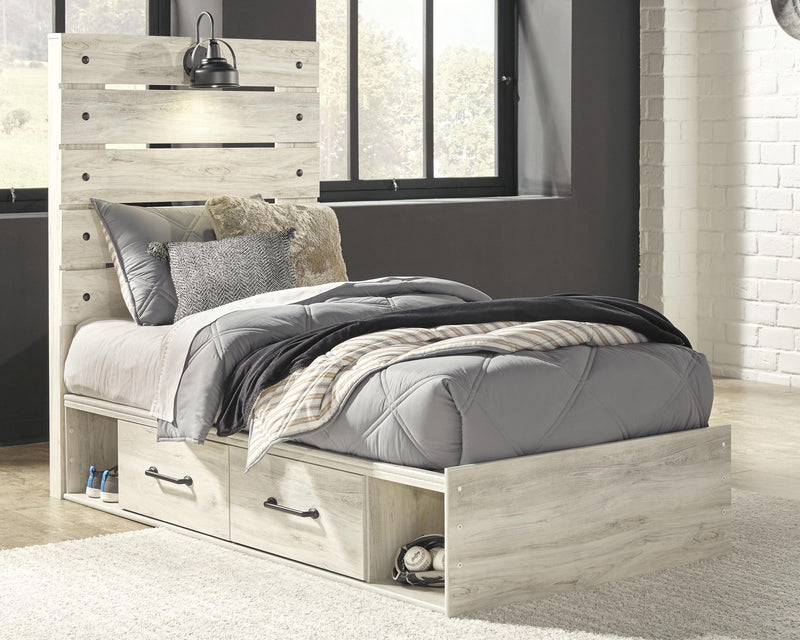 Cambeck panel bed with light wood frame, two front drawers, and upholstered bed linens