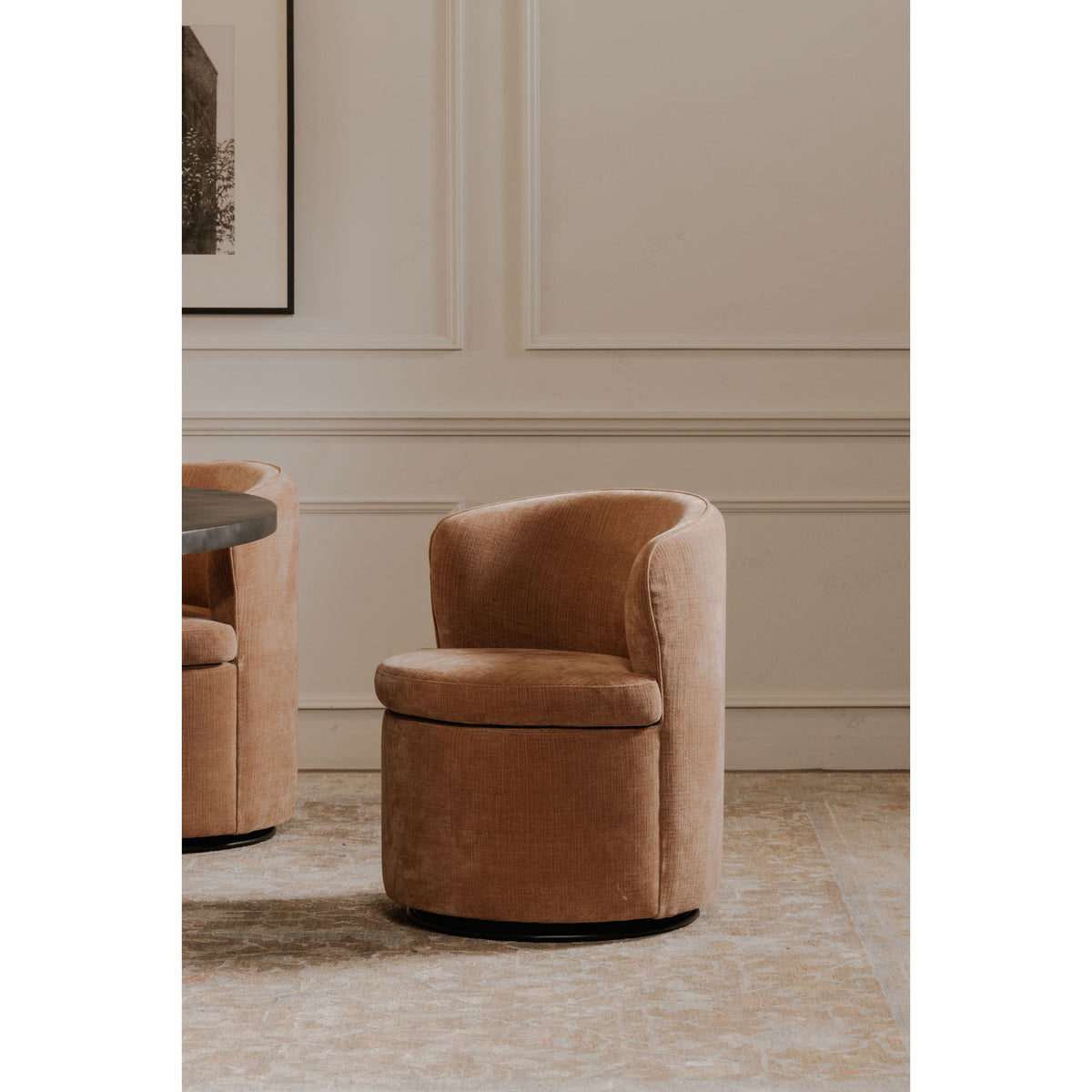 Dusty pink upholstered swivel accent chair with rounded backrest and curved arms