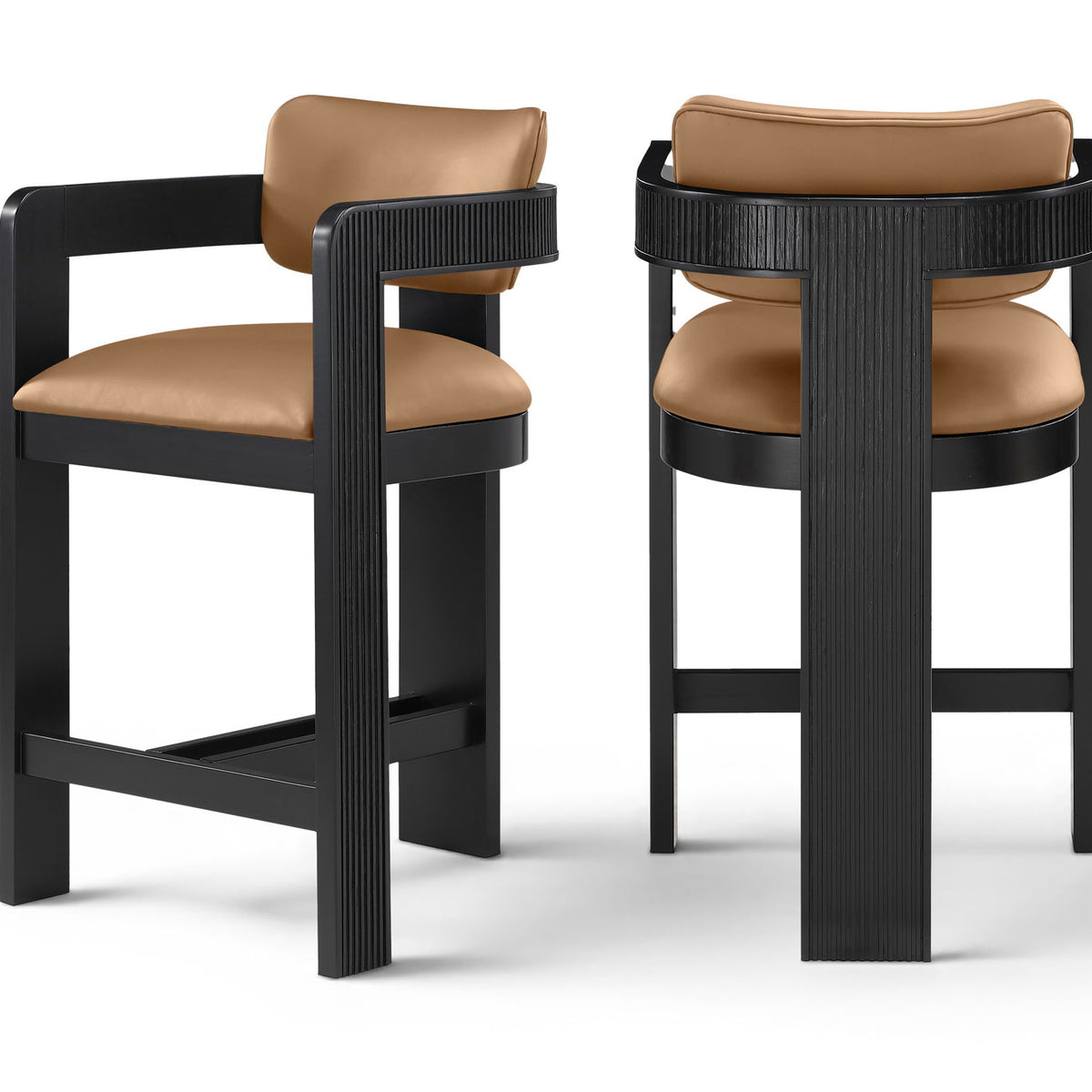 Two vegan leather counter stools with tan upholstered seats and black ribbed frames