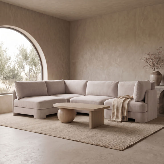 Light beige velvet armless sectional sofa with rounded arms and tufted cushions
