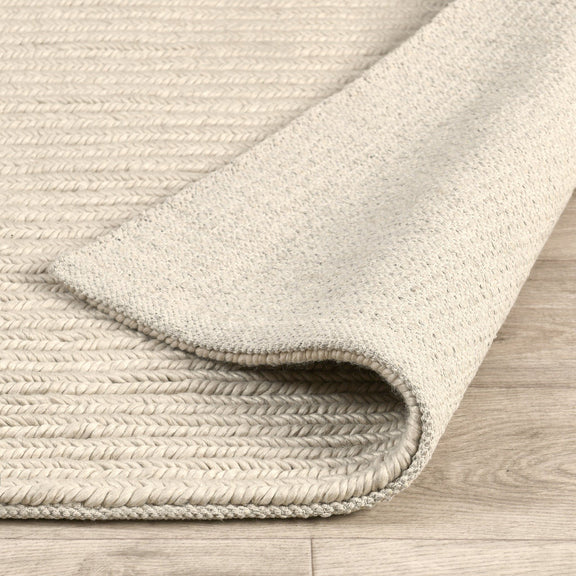 Dawson rug corner with light cream braided weave and flat bound border detail
